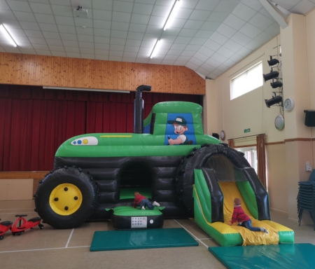 Children enjoying tractor bouncy castle
